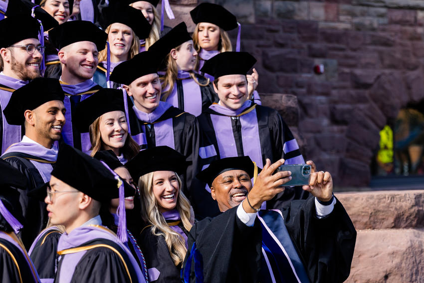 Dean Keith Mays poses for a selfie with graduating students