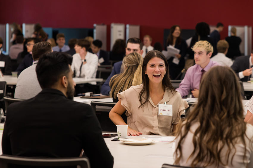 Learners talk at a table during orientation