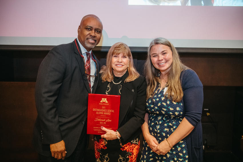 Dean Keith Mays, Deb Lien, and Shivan Nelson pose with Deb Lien's distinguished alumni award plaque