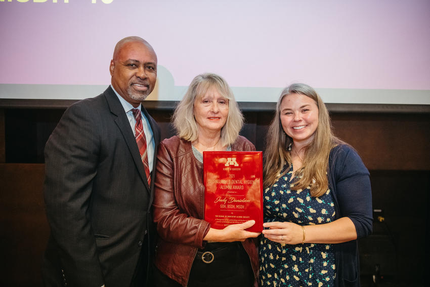 Dean Keith Mays, Judy Danielson, and Shivan Nelson pose, with Judy Danielson holding a plaque