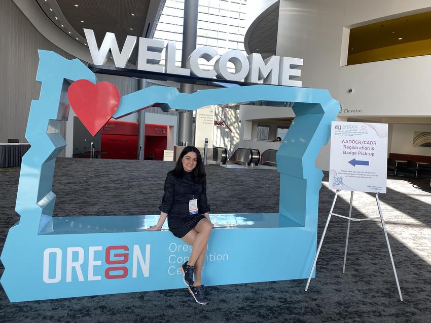 Parandis Kazemi poses with the AADOCR Oregon Welcome sign