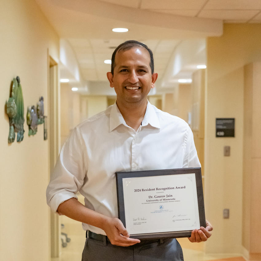 Gaurav Jain holding resident recognition award