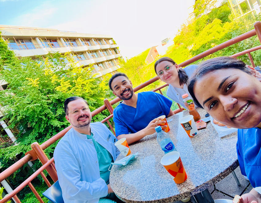 Four students take a selfie at an outdoor table in Heidelberg
