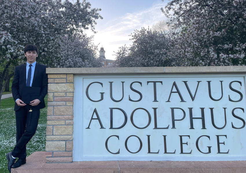 Mushtaq Wahidy next to Gustavus Adolphus College Sign