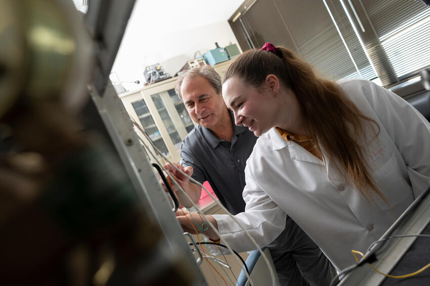 Simone works with a student on lab equipment