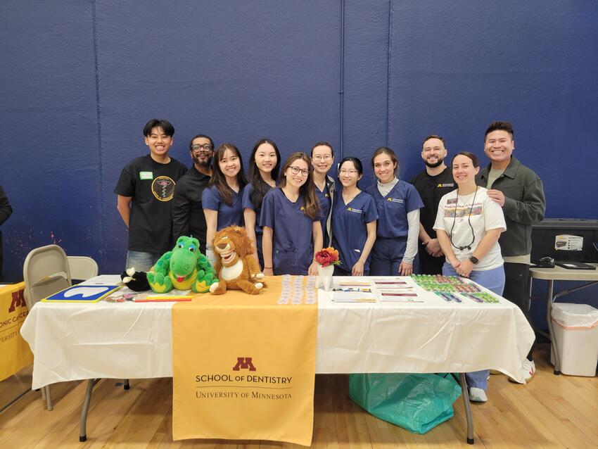 Students and staff pose at the school's booth at the Hmong fair