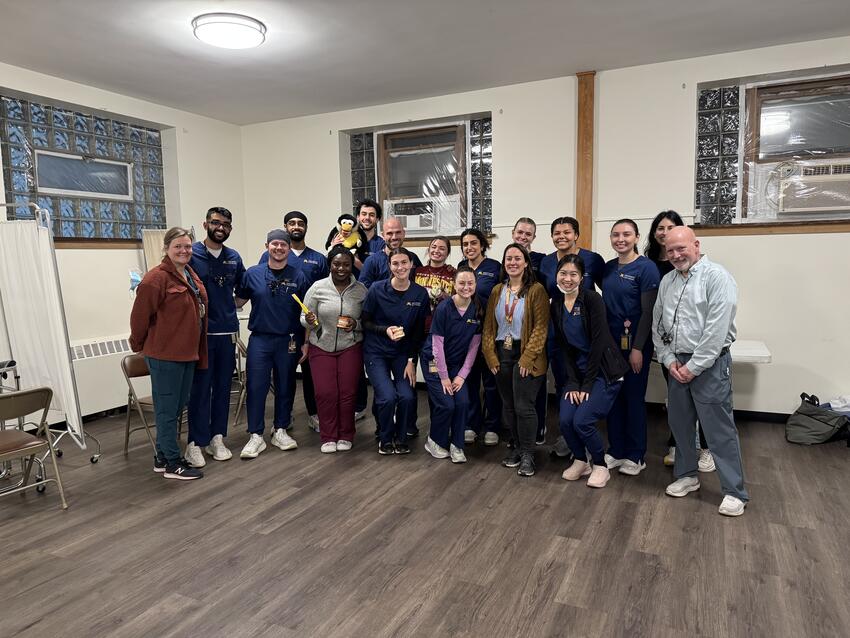 A group of students and faculty pose in the lobby of the Phillips Neighborhood Clinic