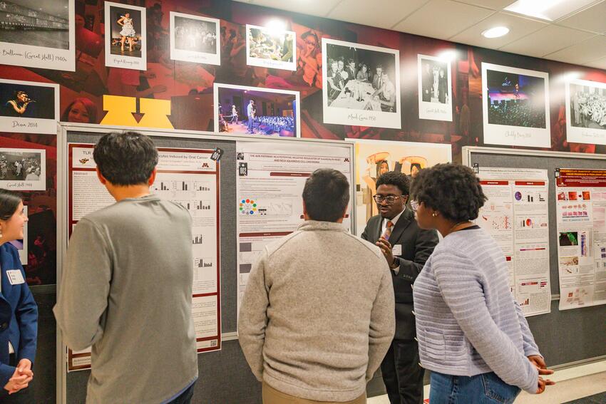A student presents his poster at Research Day