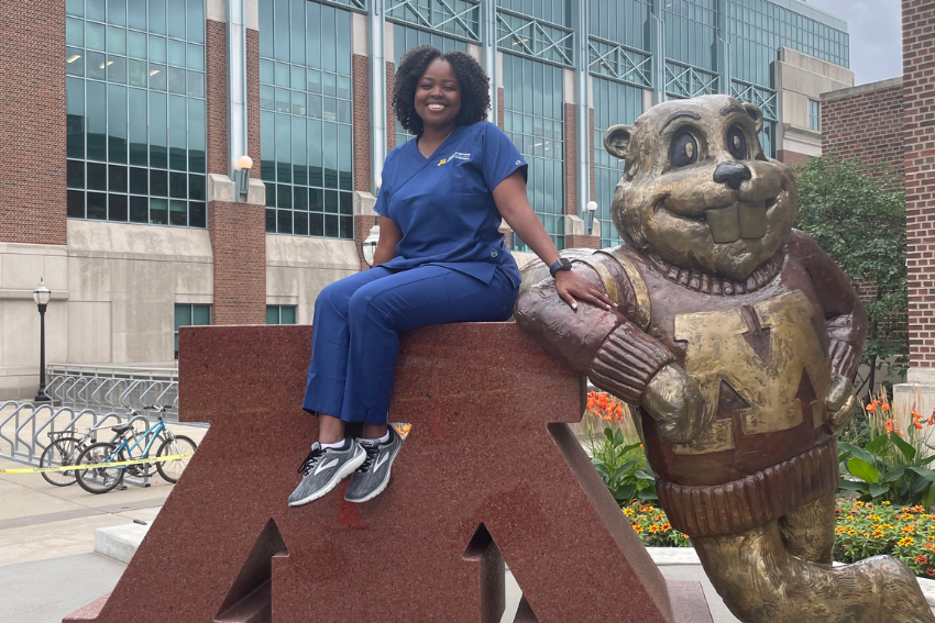 Sophie Chweya poses on the U of M Goldy statue