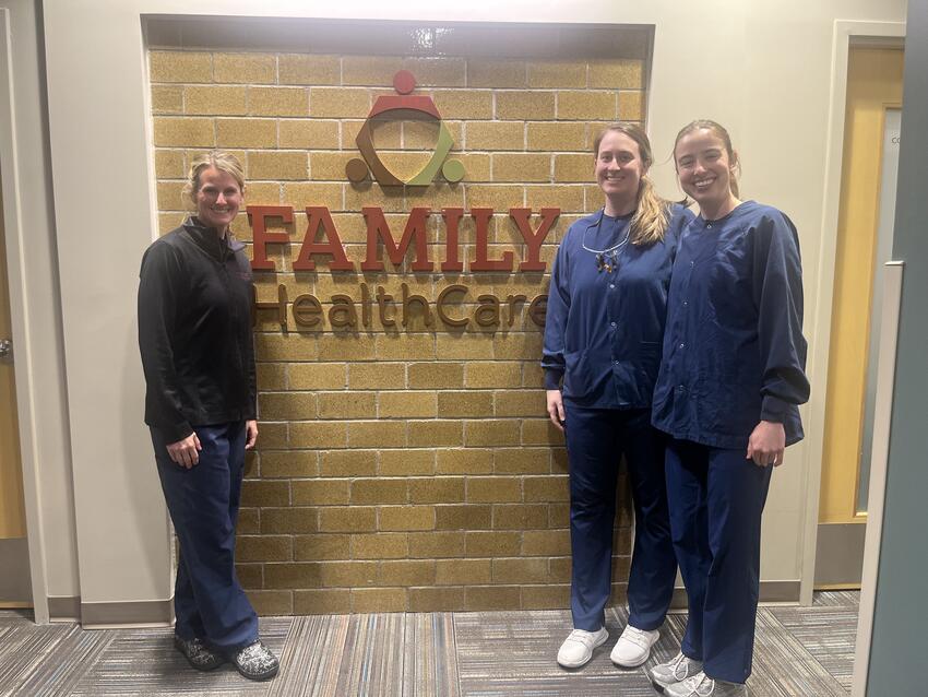 Jackie Nord and two DDS students pose in front of the Family HealthCare sign