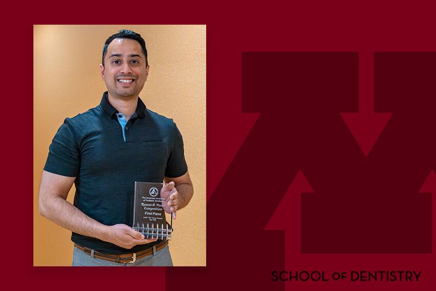Mukjerhee poses with his award on a branded background