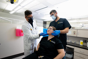 Drew Christianson and a student practice patient care on another student