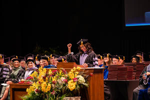 Dr Moe Anderson speaks at the podium during commencement