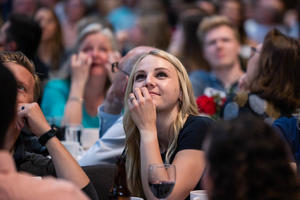 A student looks up at a screen and smiles