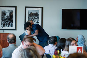Michael Abebe hugs Cyndee Stull as he receives his award