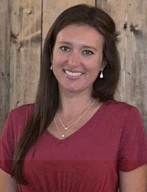 Julie Nusbaum in maroon t-shirt against wood background